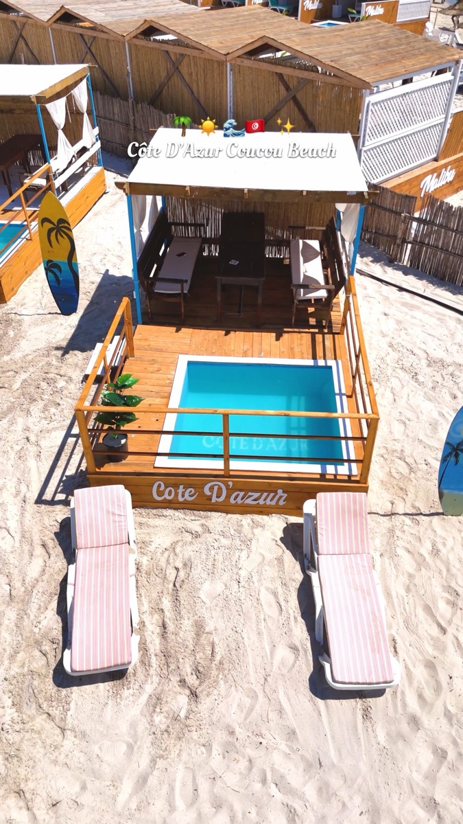 Cabane privée avec piscine et transats sur le sable