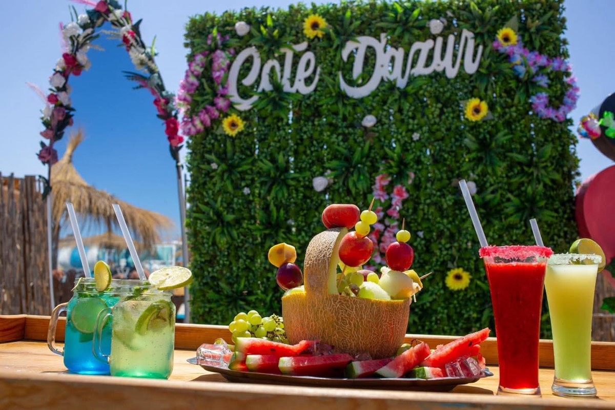 Jus frais et plateau de fruits devant le mur de fleurs
